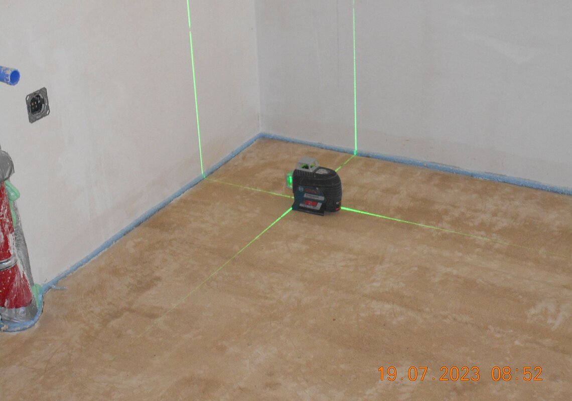 Der Fliesenleger „teilt“ mit dem Laser die Fugen des Küchenbodens ein