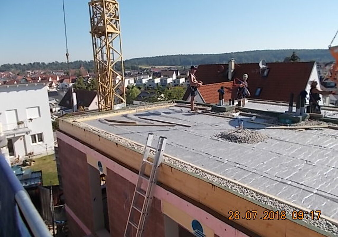 Die Drainmatte ist eingebaut, gerade wird der Kiesstreifen ausgeführt, darauf folgt der Substrateinbau der Dachbegrünung